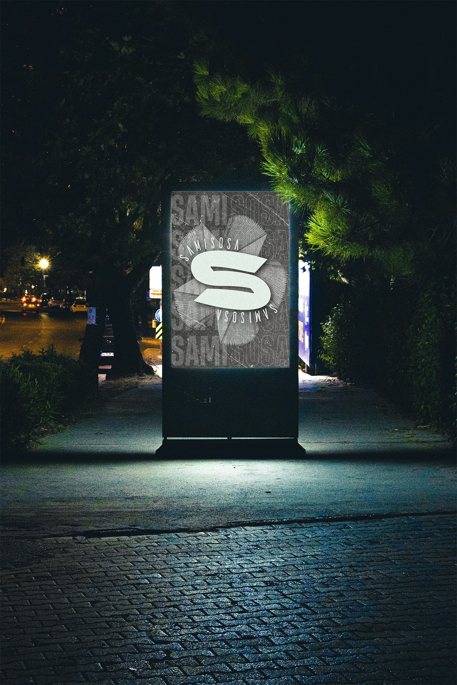 Electronic sign displaying a grey samisosa poster at night.